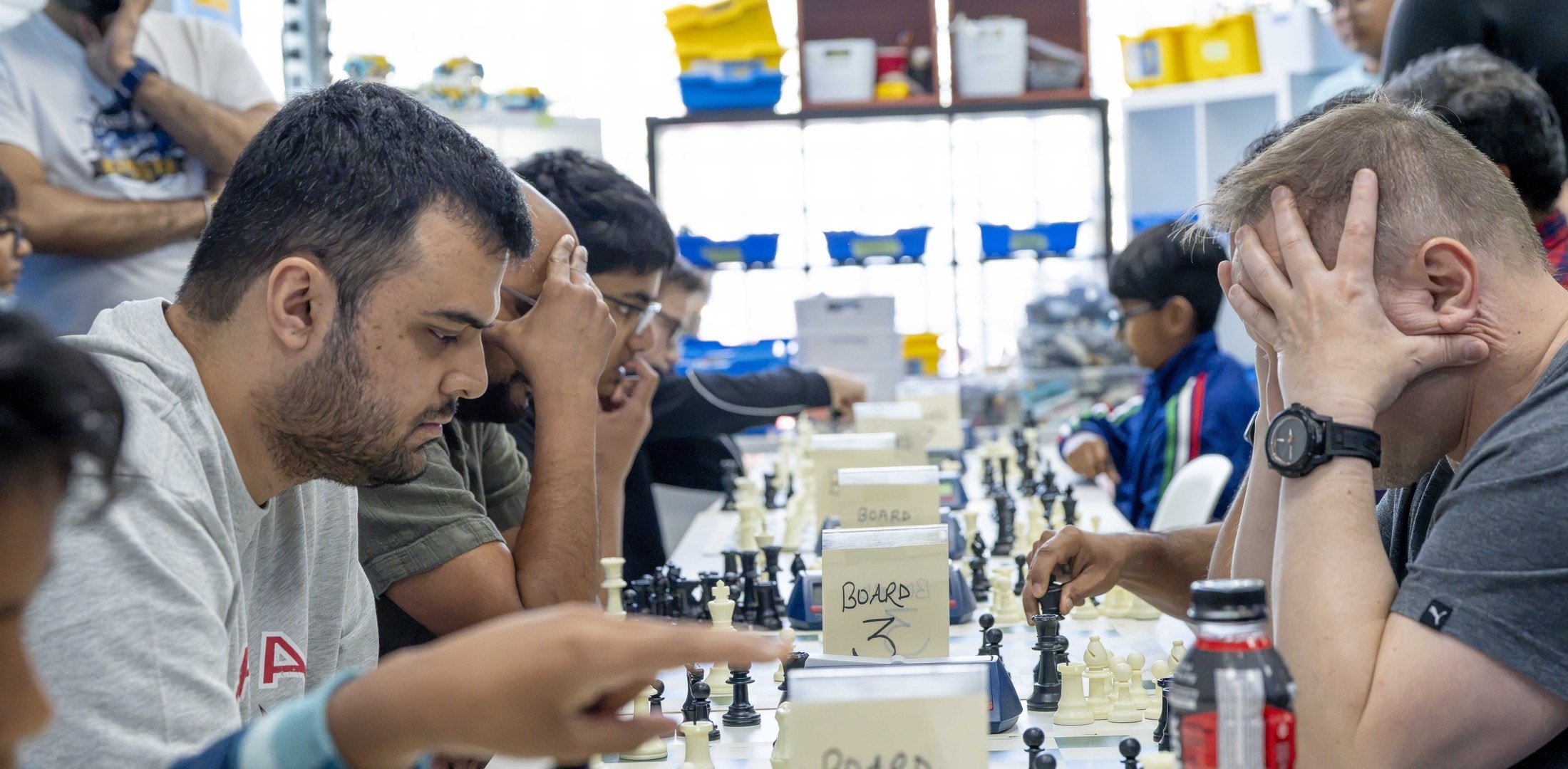 InspireBC Chess Championship 2026 — players deep in concentration across a full row of boards